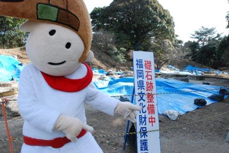 礎石跡整備中の看板前にいる大野ジョー